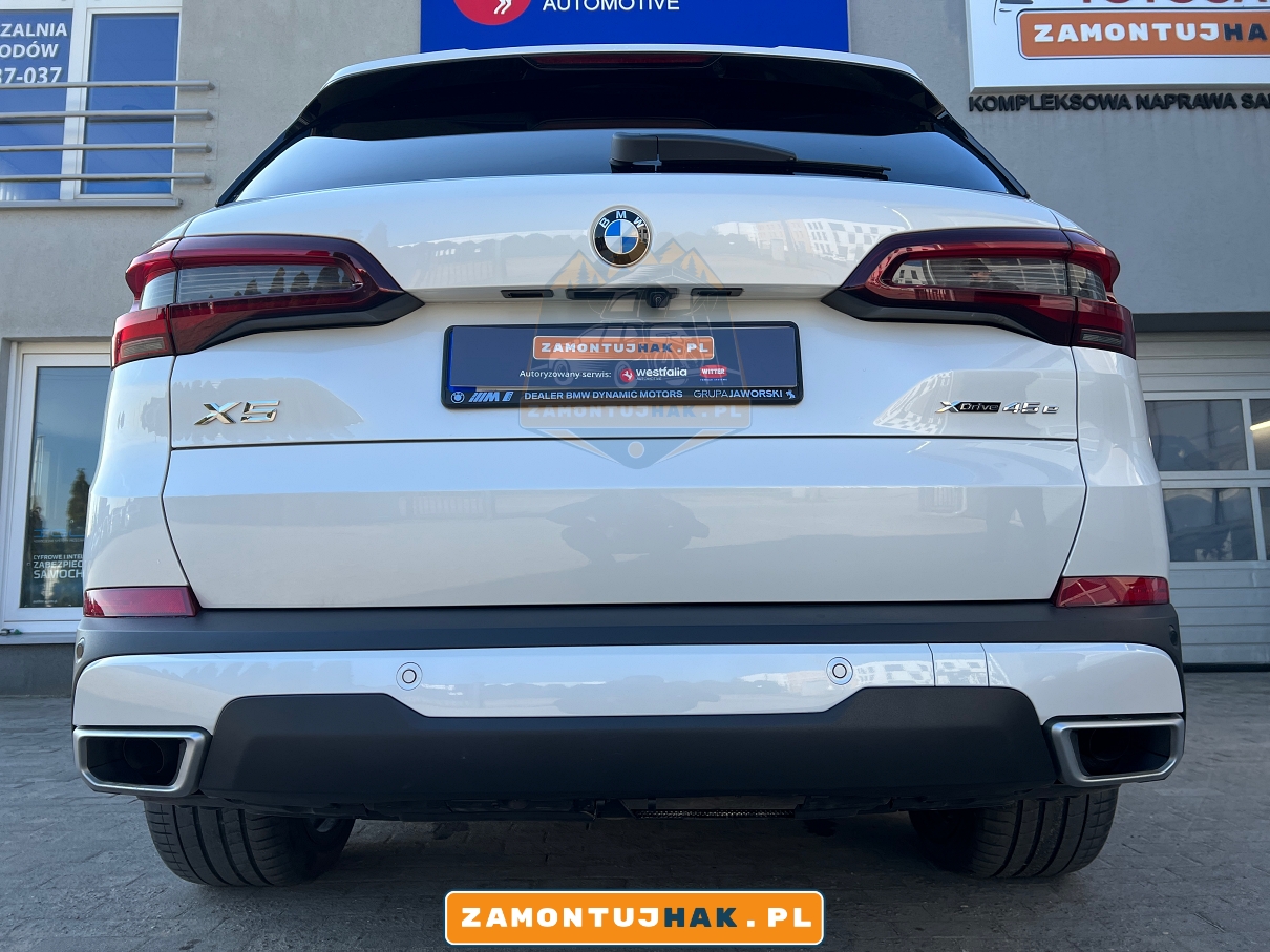 zbliżenie na tył samochodu bmw x5 g05 wersja 45e po montazu haka holowniczego w poznaniu na zdjeciu widac niewidoczne wyciecie w zderzaku brak wyciecia 